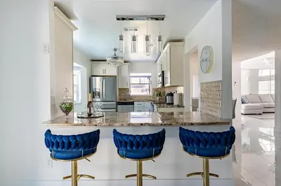 a kitchen with blue bar stools and a counter at Villa Resort Club in Kissimmee