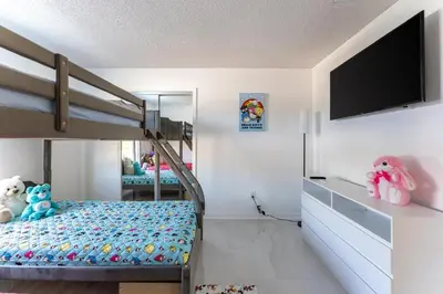 a bedroom with a bunk bed and a flat screen tv at Villa Resort Club in Kissimmee