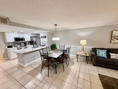 a kitchen and living room with a table and chairs at Grand Laguna 3BR Penthouse Near Disney Parks in Kissimmee