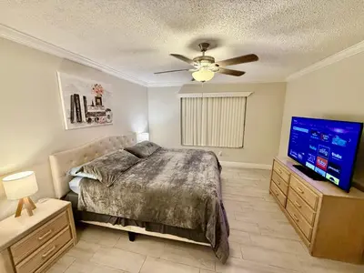 a bedroom with a bed and a flat screen tv at Grand Laguna 3BR Penthouse Near Disney Parks in Kissimmee