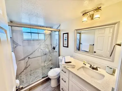a bathroom with a shower and a toilet and a sink at Grand Laguna 3BR Penthouse Near Disney Parks in Kissimmee