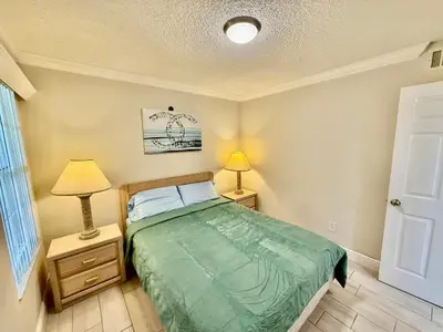 a bedroom with a bed with two night stands and two lamps at Grand Laguna 3BR Penthouse Near Disney Parks in Kissimmee