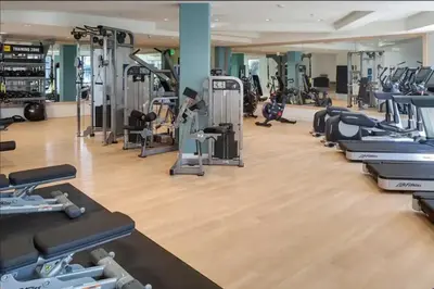 a gym with a row of treadmills and machines at Orlando Bliss Near Disney in Orlando