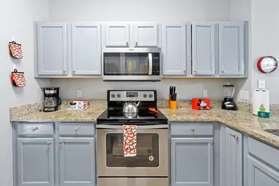 a kitchen with a stove and a microwave at Encantada Resort 10 minutes to Disney w/ Pool in Kissimmee
