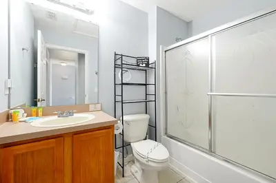 a bathroom with a toilet and a sink and a shower at Encantada Resort 10 minutes to Disney w/ Pool in Kissimmee
