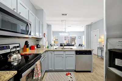a kitchen with a sink and a stove top oven at Encantada Resort 10 minutes to Disney w/ Pool in Kissimmee
