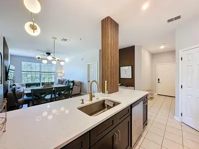a kitchen with a sink and a living room at Beautiful Three bed condo, Minutes from Disney condo in Kissimmee