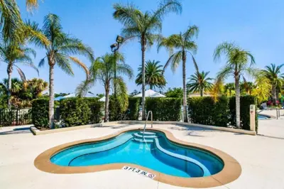 a swimming pool with palm trees in a resort at Oakwater Fountain View 3BR Home, Pool, By Disney in Orlando