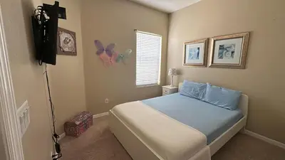 a bedroom with a bed and a television in it at Oakwater Fountain View 3BR Home, Pool, By Disney in Orlando