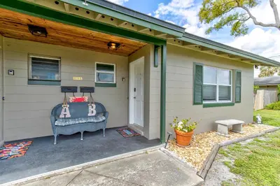 a house with a porch with a chair and a door at Downtown Duplex B Private Yard Great Location in Sanford