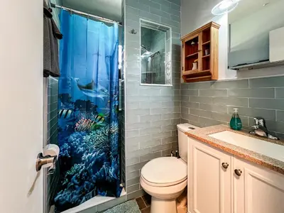 a bathroom with a shower with an aquarium shower curtain at Downtown Duplex B Private Yard Great Location in Sanford