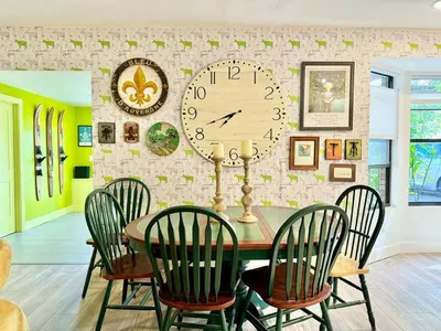 a dining room with a table and a clock on a wall at Happy Palette Home Close to downtown Fenced yard in Sanford