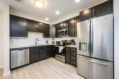 a kitchen with stainless steel appliances and wooden cabinets at New Modern Vista Cay Reserve Condo - 5006 in Orlando