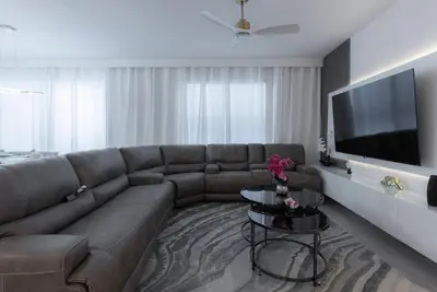 a living room with a couch and a flat screen tv at Brand New Home 8 BedroomsPoolSleeps 26 in Kissimmee