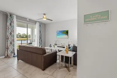 a living room with a couch and a table at Cozy & Stylish 2BR Condo Prime Storey Lake Spot in Kissimmee