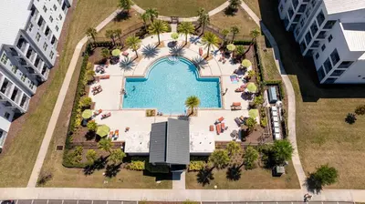 an overhead view of a swimming pool in a resort at Cozy & Stylish 2BR Condo Prime Storey Lake Spot in Kissimmee