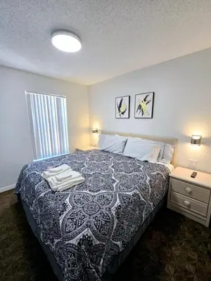 a bedroom with a bed with a black and white blanket at Casa Maria- A piece of Heaven in Kissimmee