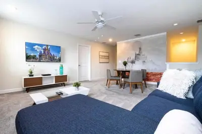 a living room with a blue bed and a dining room at Villa 6Q Disney Style c/ Piscina e Game Room in Kissimmee
