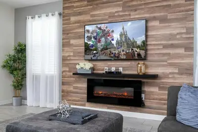 a living room with a fireplace and a flat screen tv at Villa 6Q Disney Style c/ Piscina e Game Room in Kissimmee