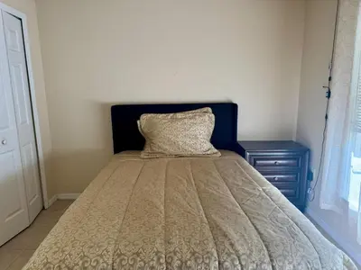 a bedroom with a bed with a pillow and a nightstand at 4701-Lake Berkley villa- Renovated 3 bed in Kissimmee