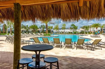 a patio with a table and chairs and a pool at Casa 4Q com Piscina Aquecível — Storey Lake in Kissimmee