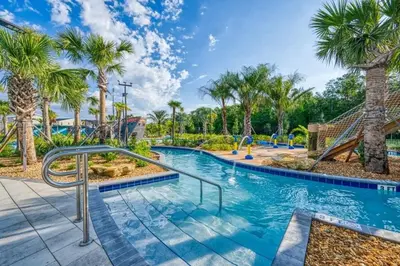 a pool with palm trees and a slide at Casa 4Q com Piscina Aquecível — Storey Lake in Kissimmee