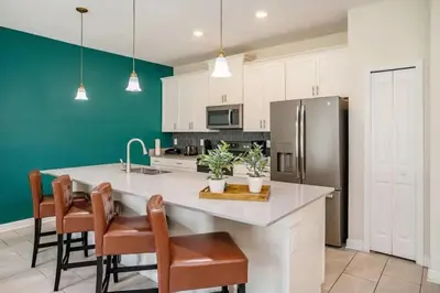 a kitchen with a white counter and a refrigerator at Casa 4Q com Piscina Aquecível — Storey Lake in Kissimmee