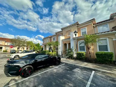 a black car parked on a street in front of houses at Grand Panoramic 3BR Townhouse Near Disney Parks in Kissimmee