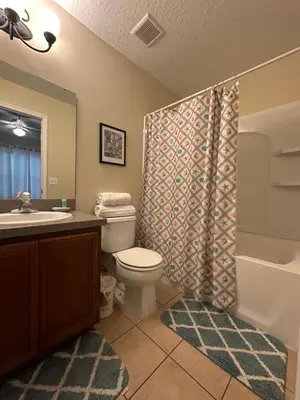 a bathroom with a toilet and a sink and a shower at Grand Panoramic 3BR Townhouse Near Disney Parks in Kissimmee