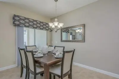 a dining room with a wooden table and chairs at Amplo Townhome 4 Quartos com Piscina Privativa in Kissimmee