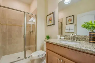 a bathroom with a shower and a toilet and a sink at Amplo Townhome 4 Quartos com Piscina Privativa in Kissimmee