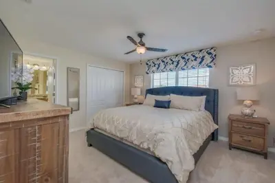 a bedroom with a bed and a dresser and a television at Amplo Townhome 4 Quartos com Piscina Privativa in Kissimmee