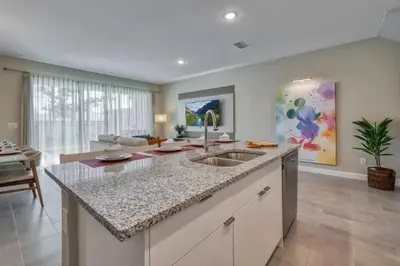 a kitchen with a sink and a living room at Casa 5Q com Piscina Privativa no Formosa in Orlando