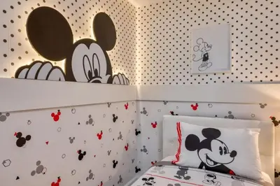 a bedroom with a bed with a mickey mouse wallpaper at Casa 5Q com Piscina Privativa no Formosa in Orlando
