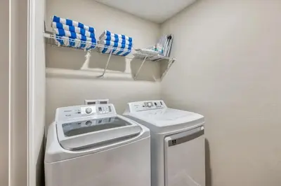 a small laundry room with a washer and dryer at Casa 5Q com Piscina Privativa no Formosa in Orlando