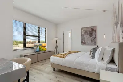 a white bedroom with a bed and a window at Grand 15-Bedroom Villa -Magical Themes Pool & Game Loft Lakeview in Kissimmee