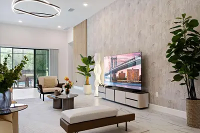 a living room with a flat screen tv on a wall at Grand 15-Bedroom Villa -Magical Themes Pool & Game Loft Lakeview in Kissimmee