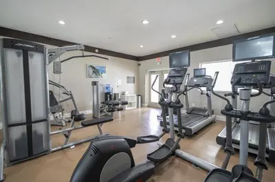 a gym with treadmills and ellipticals in a room at Near Universal Parks Cozy Apartament at The Point in Orlando