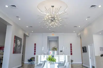 a large white room with a chandelier on the ceiling at Near Universal Parks Cozy Apartament at The Point in Orlando