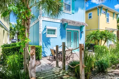 a blue house with a table in front of it at Palm Tree Paradise Cottage Near Disney With Margaritaville Resort & Island H20 Waterpark Access - 3087Pi in Orlando