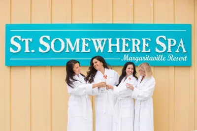 a group of women in white robes standing in front of a sign at Palm Tree Paradise Cottage Near Disney With Margaritaville Resort & Island H20 Waterpark Access - 3087Pi in Orlando