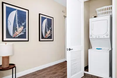a room with a white refrigerator and pictures of boats on the wall at Waterfront Cottage With Balcony And Private Pool Near Disney And Margaritaville Resort & Island H20 Waterpark Access - 3008Ph in Orlando