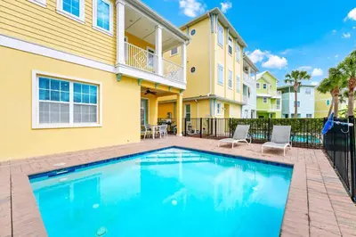 a swimming pool in front of a building with a house at Waterfront Cottage With Balcony And Private Pool Near Disney And Margaritaville Resort & Island H20 Waterpark Access - 3008Ph in Orlando