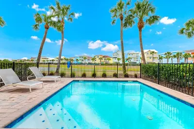 a swimming pool with two chairs and palm trees at Waterfront Cottage With Balcony And Private Pool Near Disney And Margaritaville Resort & Island H20 Waterpark Access - 3008Ph in Orlando