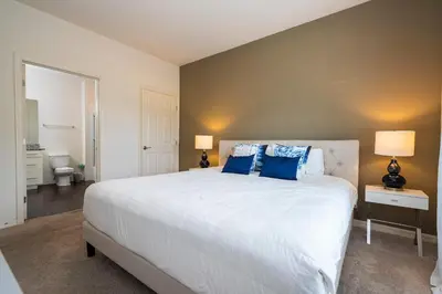 a bedroom with a large white bed with blue pillows at Spacious 4Bd Disney Dream with Resort Access at Lucaya 3210 in Kissimmee