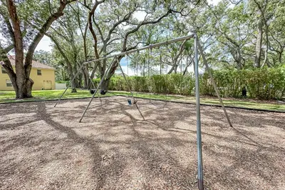 an empty swing set in a park with trees at Stunning 3 bedroom 3 bath townhome 370 in Kissimmee
