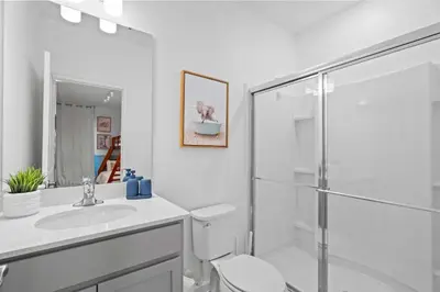 a white bathroom with a toilet and a shower at Luxury Paradise in Orlando Best Location in Orlando