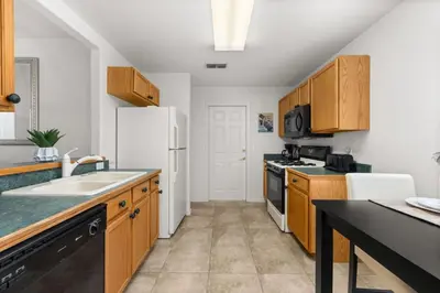 a kitchen with wooden cabinets and a white refrigerator at Family favorite Disney pool home in Kissimmee
