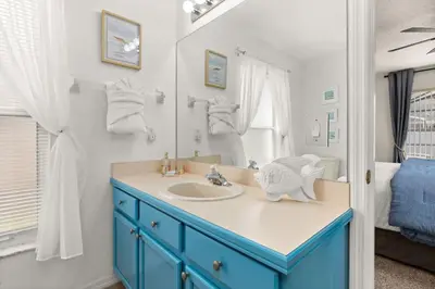 a bathroom with a blue cabinet and a sink at Family favorite Disney pool home in Kissimmee