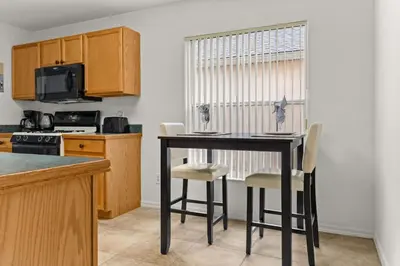 a kitchen with a table and chairs in a room at Family favorite Disney pool home in Kissimmee